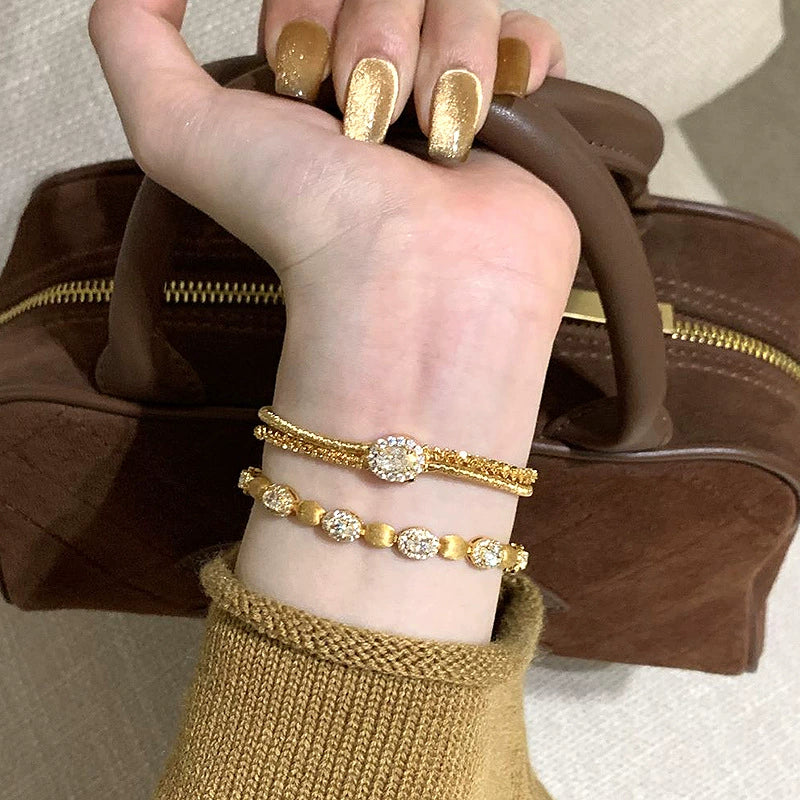 Gold wire bracelet with multiple strands of gold wire, stacked copper alloy bracelet