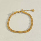 Stainless steel stacked bracelet with PVD-plated small gold beads and gold chain